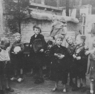 876763 Afbeelding van een groepje kinderen wachtend op de voedseluitdeling uit de gaarkeuken gerund door de Zusters ...